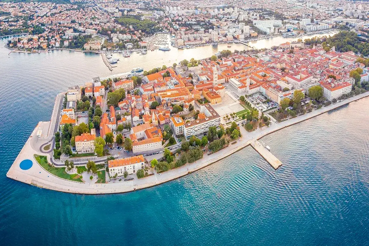 Vista aerea della Zara citt&agrave; con tetti arancioni, mare blu e il Pozdrav Suncu.