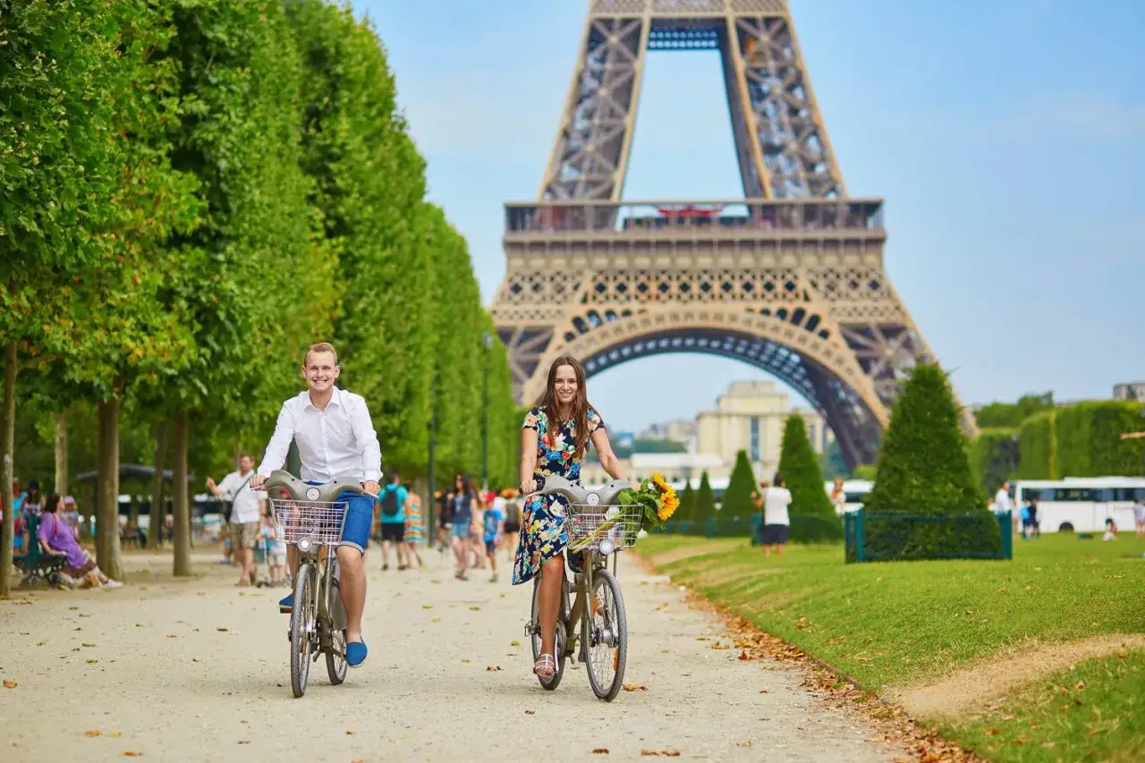 Pareja en bicicleta en Par&iacute;s, celebrando San Valent&iacute;n en Francia. La Torre Eiffel de fondo.