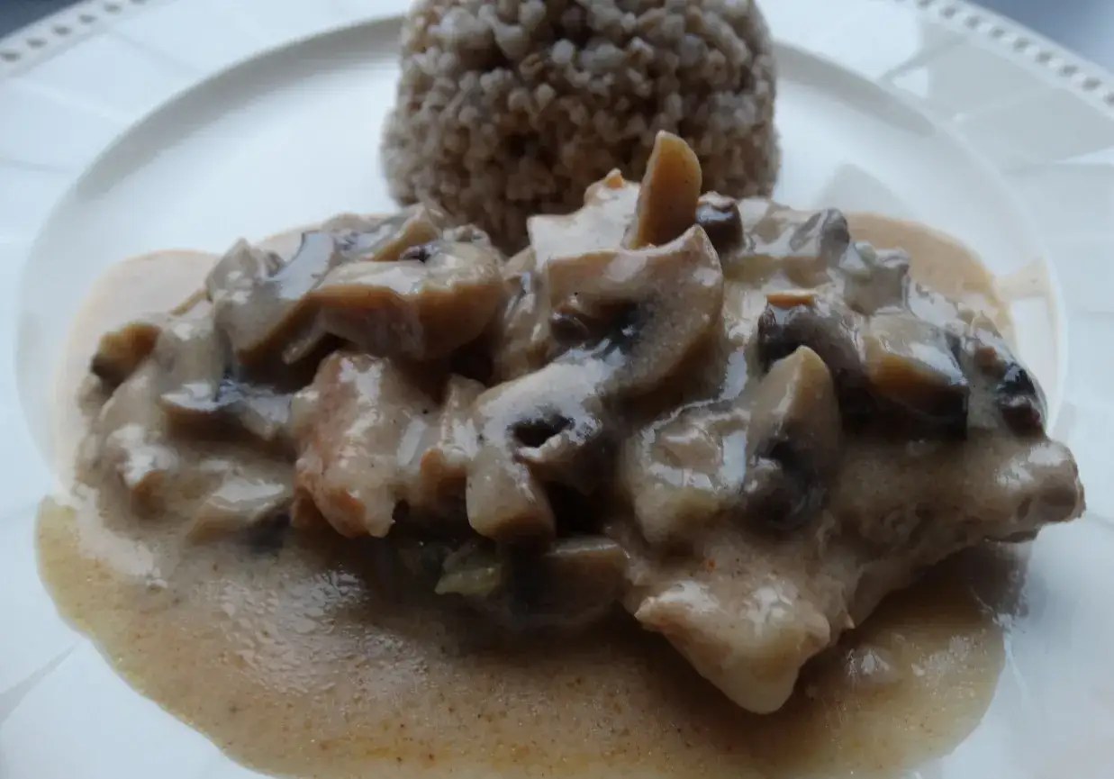 Pyszny schab duszony z pieczarkami w kremowym sosie, podany z kaszą gryczaną.