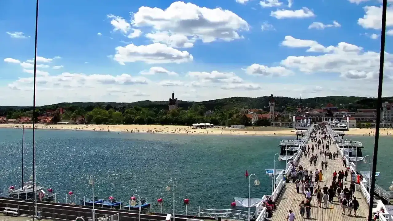 Spacer po najdłuższym molo w Polsce. Tłumy ludzi spacerują, podziwiając morze i plażę z widokiem na Sopot.