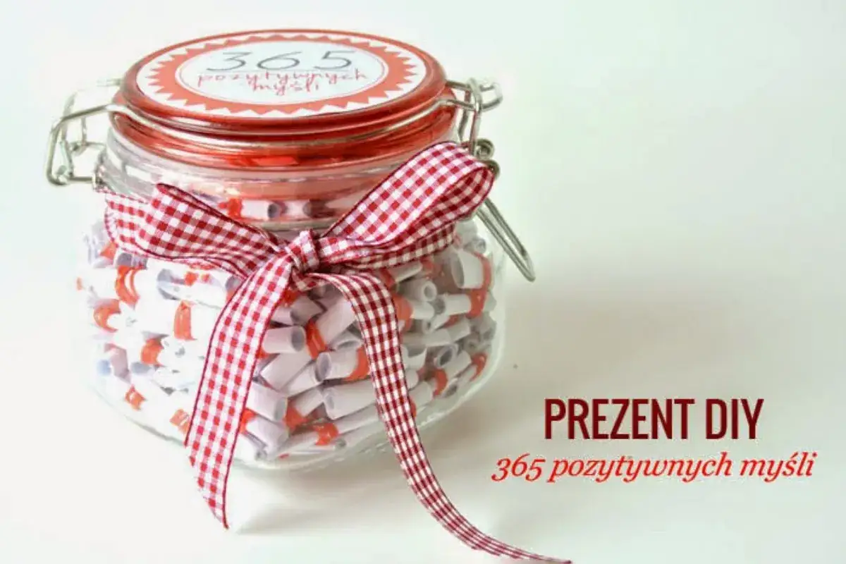 Słoik pełen karteczek z miłymi słowami, ozdobiony czerwoną wstążką. Idealny prezent DIY na każdy dzień roku.