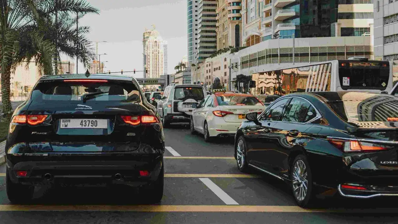 Korki w Dubaju. Luksusowe samochody, w tym Jaguar i Lexus, stoją w rzędzie. Marzenie o złota wiza dubaj staje się rzeczywistością.
