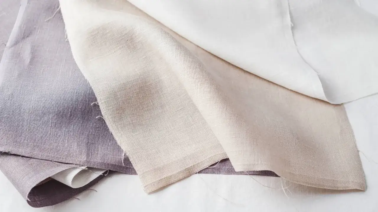 &Eacute;chantillons de tissus en lin, du violet au beige, pr&ecirc;ts &agrave; d&eacute;tacher le linge blanc.