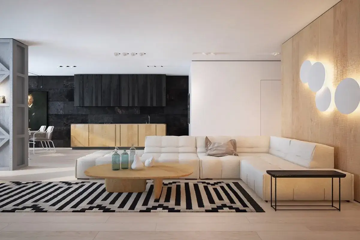 Elegante sal&oacute;n con sof&aacute; blanco modular, mesa de centro de madera clara y alfombra geom&eacute;trica. La pared de fondo combina muebles blancos y madera oscura, creando un contraste sofisticado.