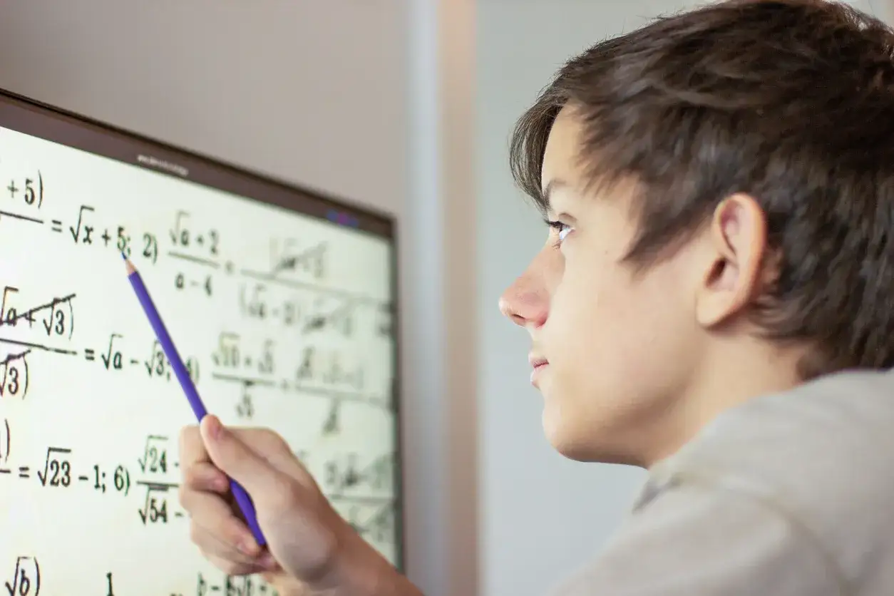 Un chico estudia matem&aacute;ticas en una pantalla, resolviendo ejercicios de polinomios 2 eso.