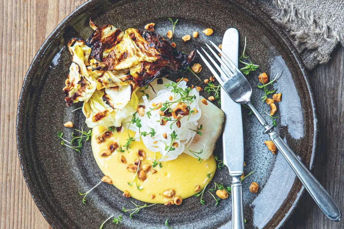 Lyxig torskrygg med rostad k&aring;l, kr&auml;mig s&aring;s och n&ouml;tter. Ett recept som garanterat imponerar.
