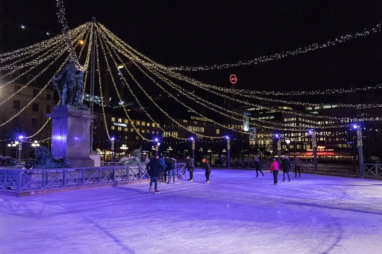 Människor njuter av skridskoåkning i Stockholm under en gnistrande ljusshow.