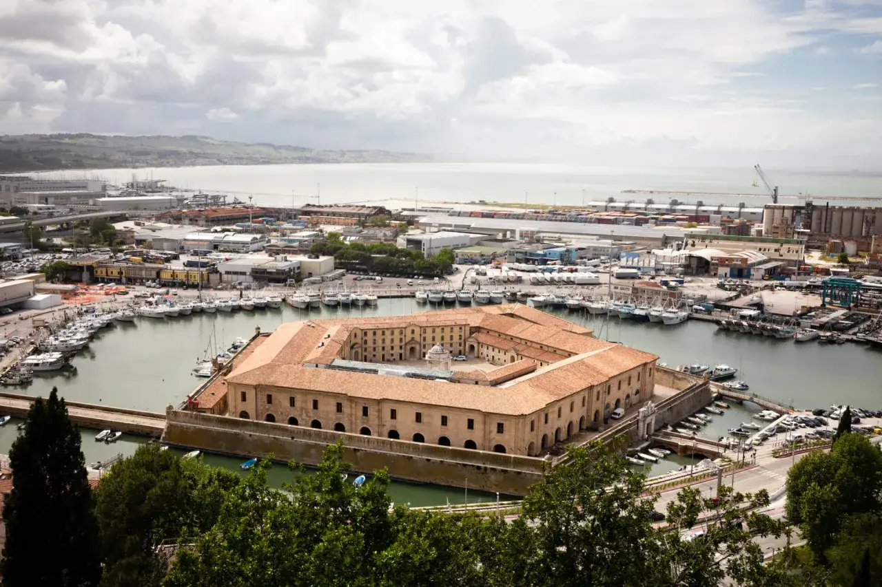 Vista panoramica del porto di Ancona, Marche, con la Mole Vanvitelliana al centro e numerose imbarcazioni ormeggiate.