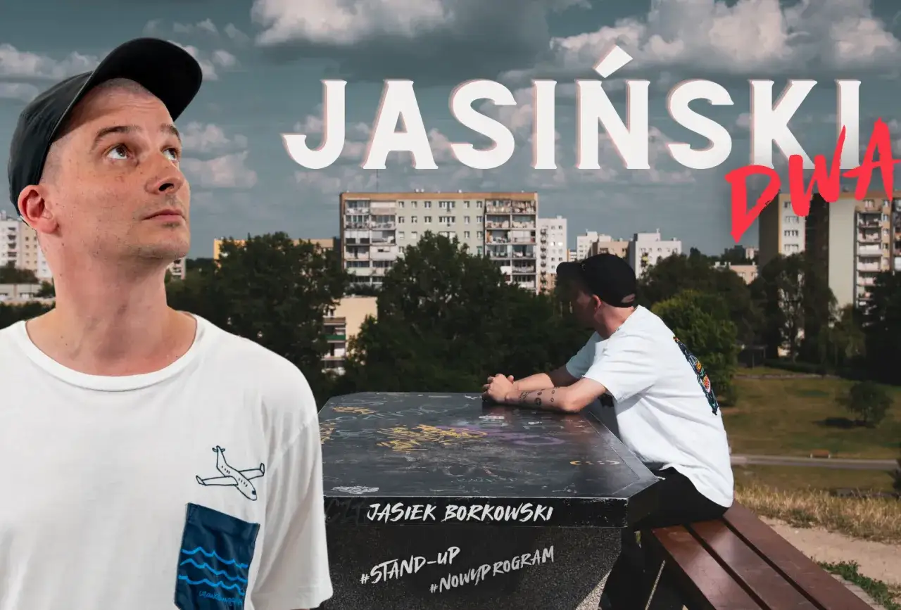 Jasiek Borkowski stand up. Dwóch mężczyzn w czapkach z daszkiem, jeden patrzy w górę, drugi siedzi przy stoliku z graffiti.