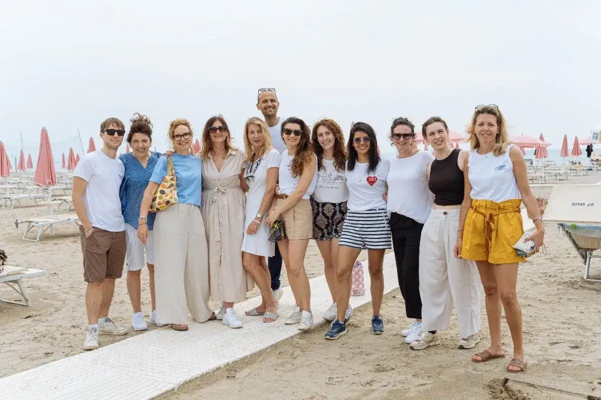 Un gruppo di amici in spiaggia, sorridenti e abbronzati. Chissà quanto tempo ci vuole per abbronzarsi così!