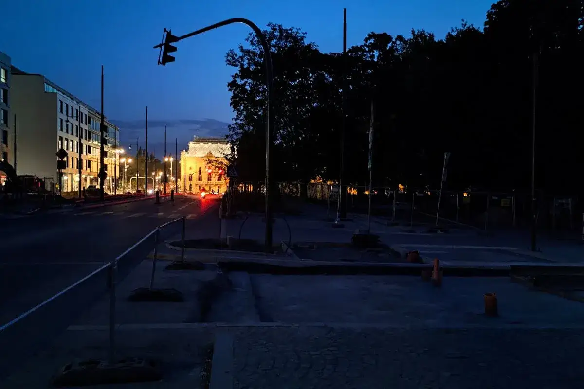 Zmierzch w Łodzi. Ulica z latarniami, budynkami i sygnalizacją świetlną. Czy łódź jest bezpiecznym miastem?