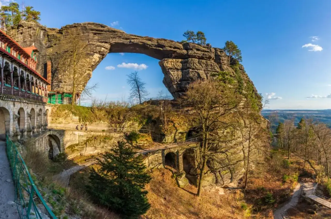 Majestatyczna Pravcicka Brana, największa naturalna brama skalna w Europie, góruje nad krajobrazem. Obok niej zabytkowy zamek.