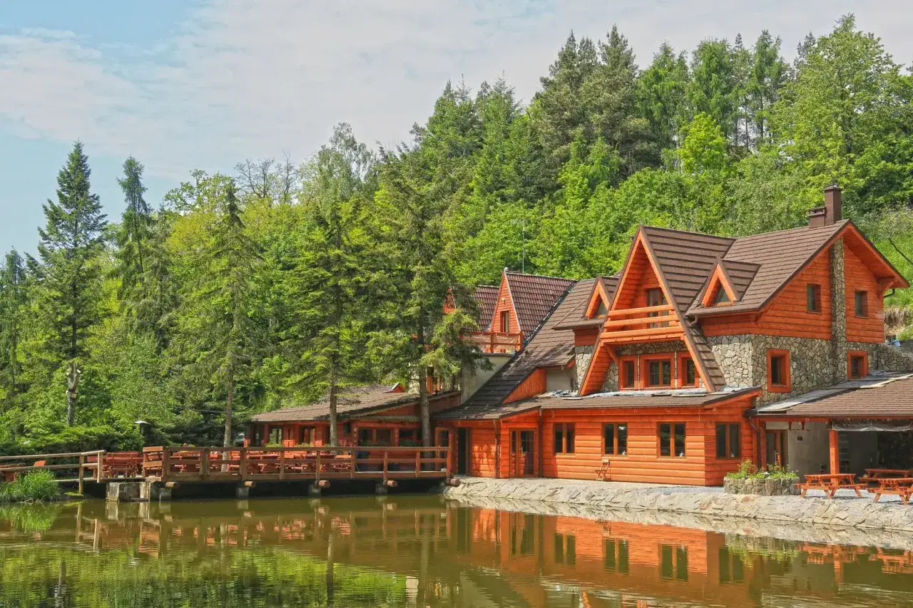 Drewniane domy nad jeziorem, otoczone lasem, idealne na wypoczynek. W pobliżu znajduje się restauracja 