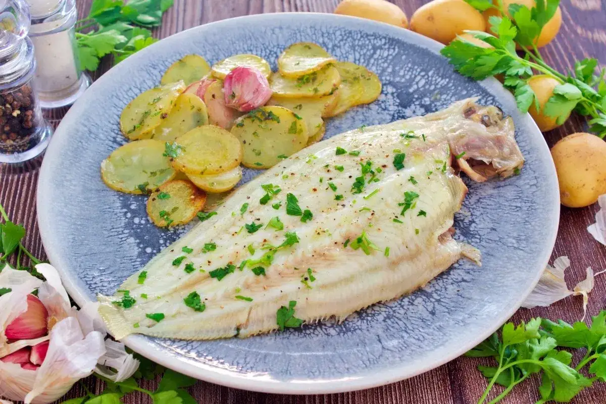 Delicioso lenguado al horno con patatas panadera y perejil fresco. Un plato ligero y sabroso.