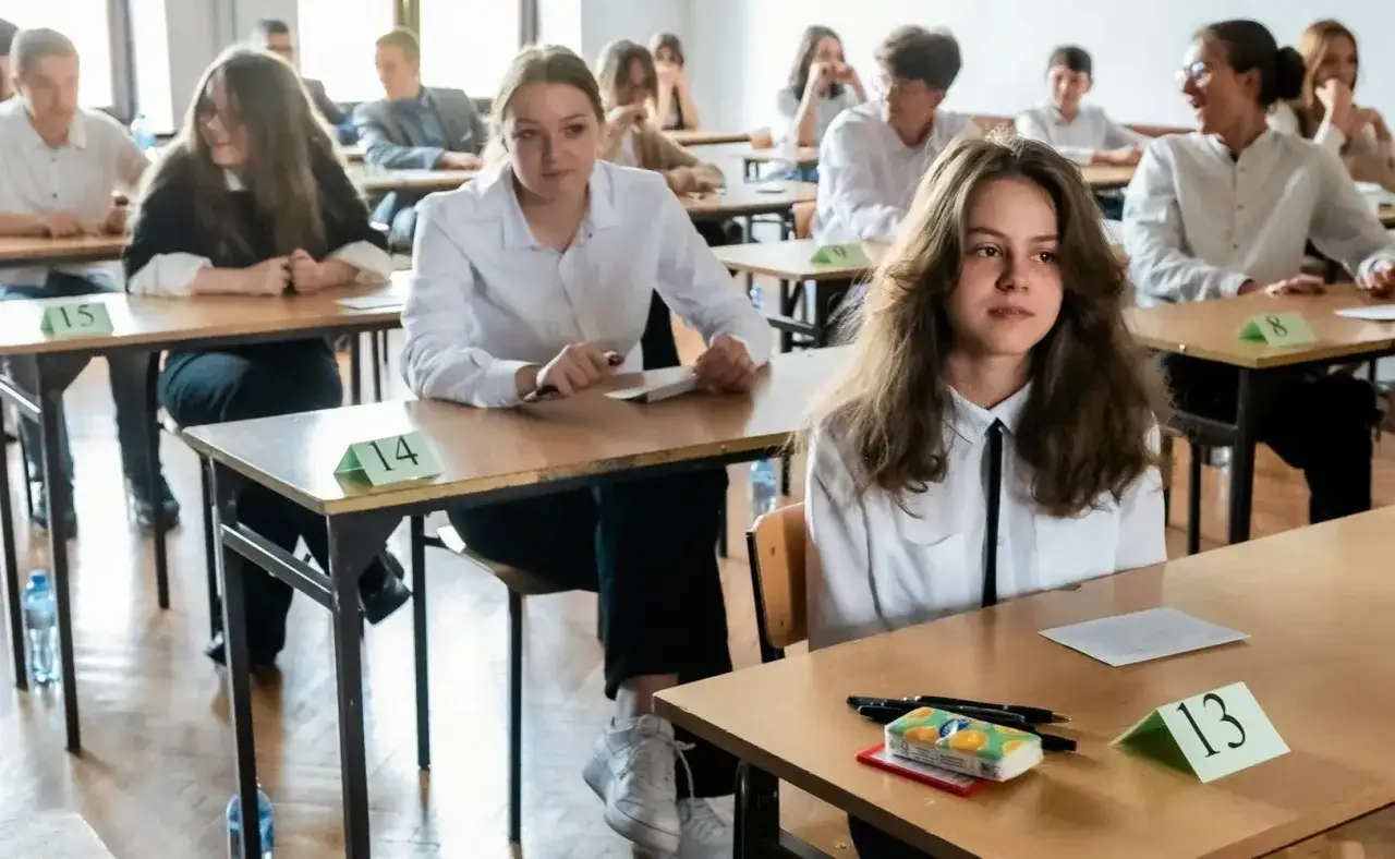 Uczniowie siedzą w ławkach, pisząc egzamin. Tak wygląda rekrutacja do liceum.