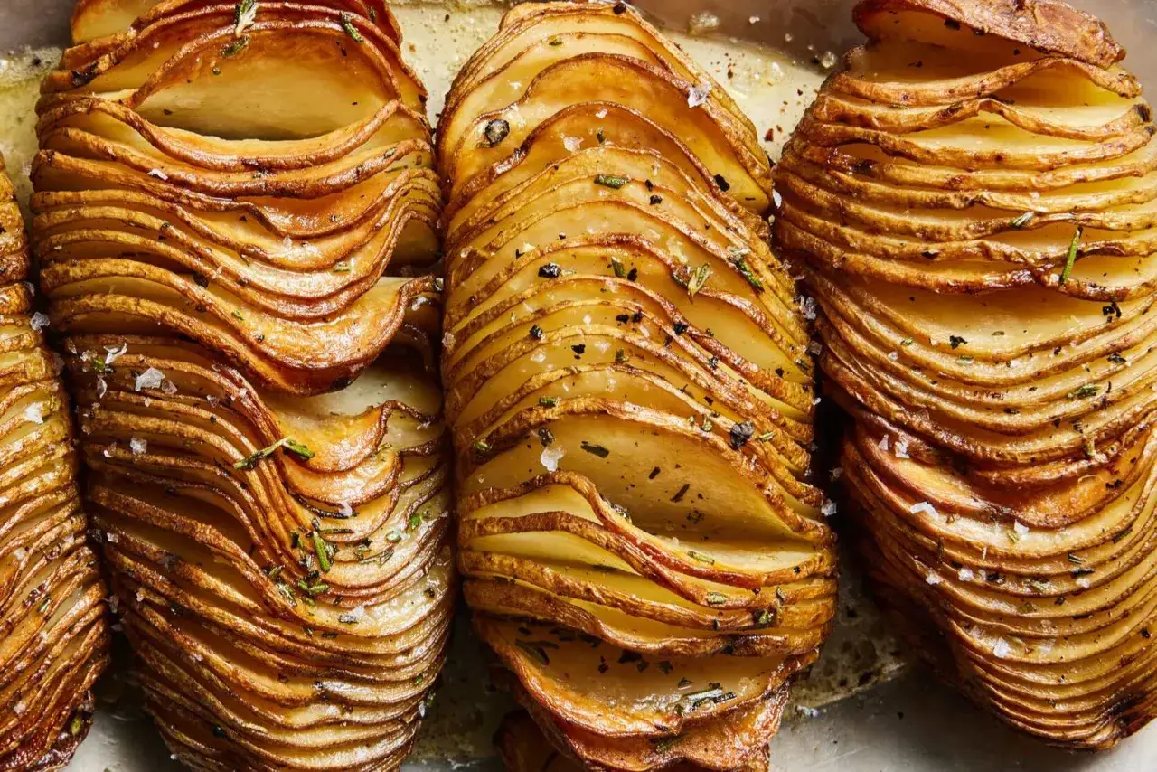 Krispiga hasselbackspotatisar med örter och flingsalt, ett perfekt recept för en festlig middag.