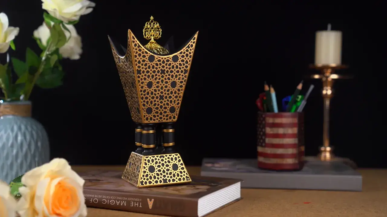 Ein kunstvoller Weihrauchbrenner im islamischen Stil, verziert mit goldenen geometrischen Mustern, steht auf einem Buch.