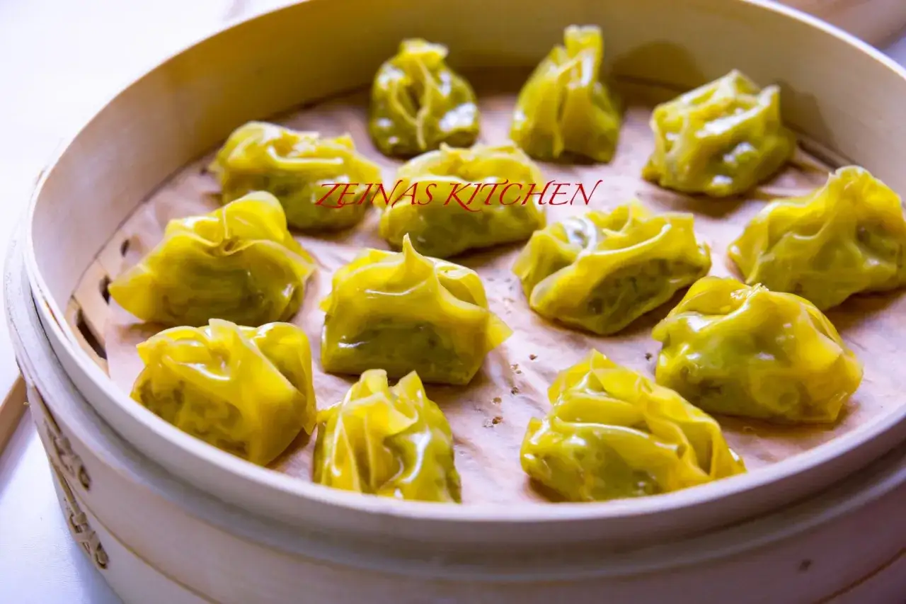 En &aring;ngad bambukorg fylld med gyllene afghanska mantu-dumplings.