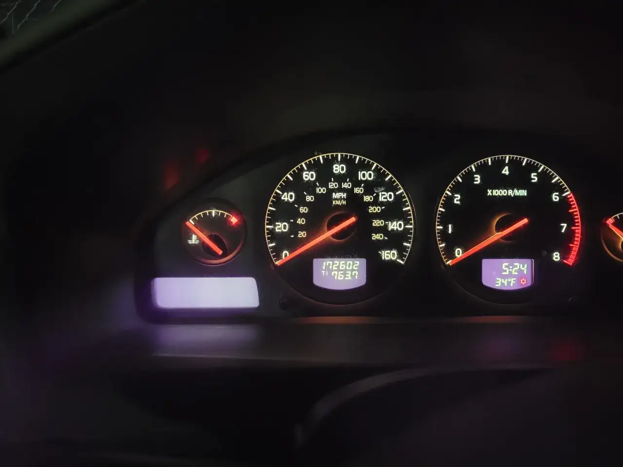 Instrumentpanelen på en Volvo S80 visar hastighet, varvtal och temperatur. En varningslampa lyser, vilket indikerar ett problem.