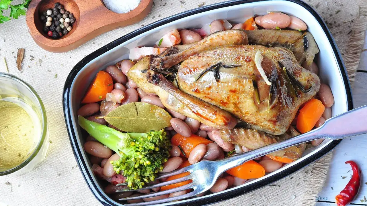 Ein herzhafter Braten von Tauben mit Bohnen, Karotten und Brokkoli, serviert in einer Auflaufform.