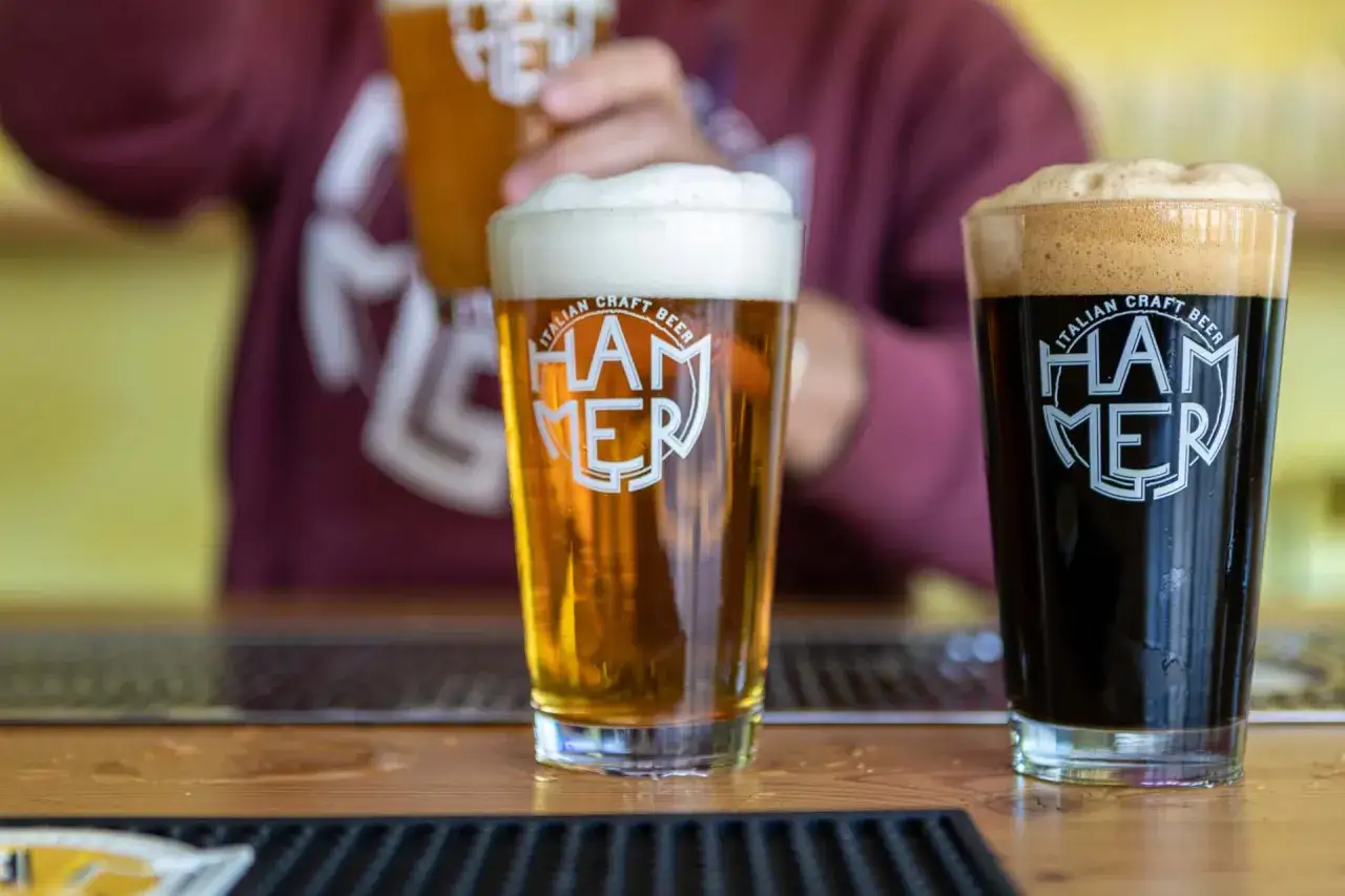 Due bicchieri di birra artigianale italiana, una chiara e una scura, con schiuma abbondante. La birra pi&ugrave; buona per una serata perfetta.