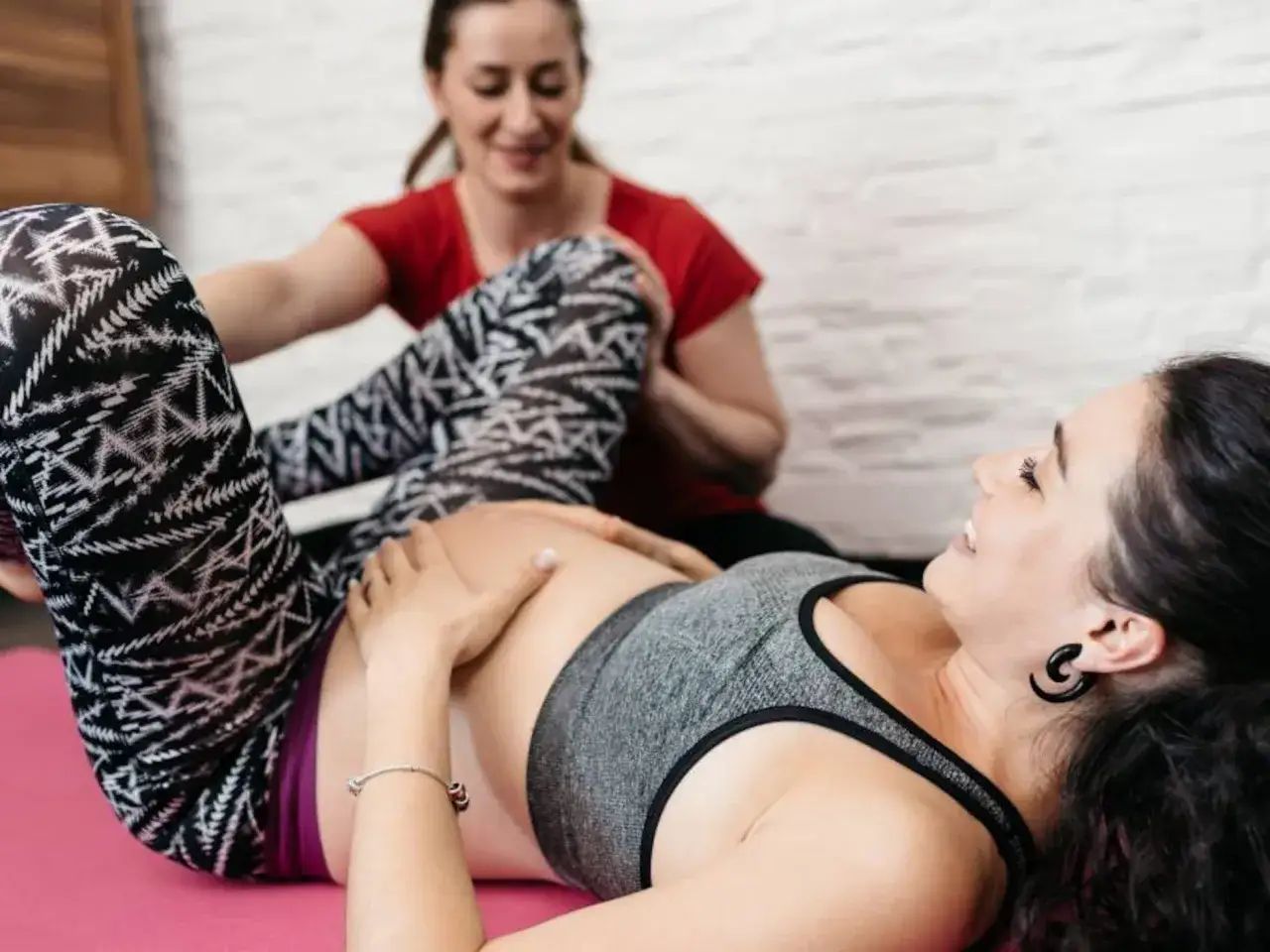 Una doula ayuda a una mujer embarazada con ejercicios. La doula que es, acompa&ntilde;a y apoya en esta etapa.
