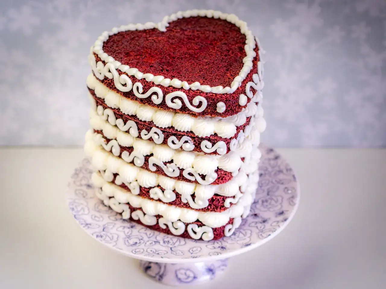 Herzf&ouml;rmiger Red Velvet Cake mit wei&szlig;er Creme-Dekoration, inspiriert vom red velvet cake rezept original.