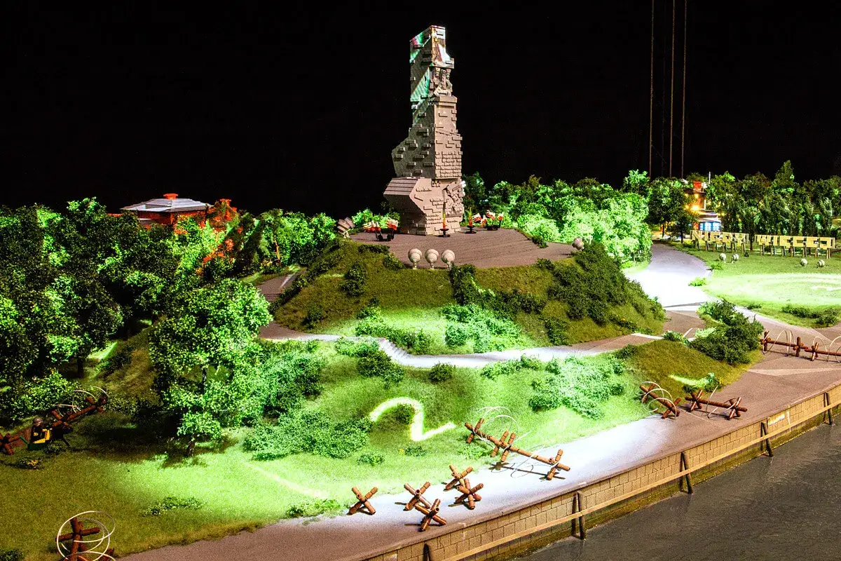 Miniatura pomnika i krajobrazu w HistoryLand Kraków. Widać drzewa, wzgórza, ścieżki i elementy fortyfikacji.