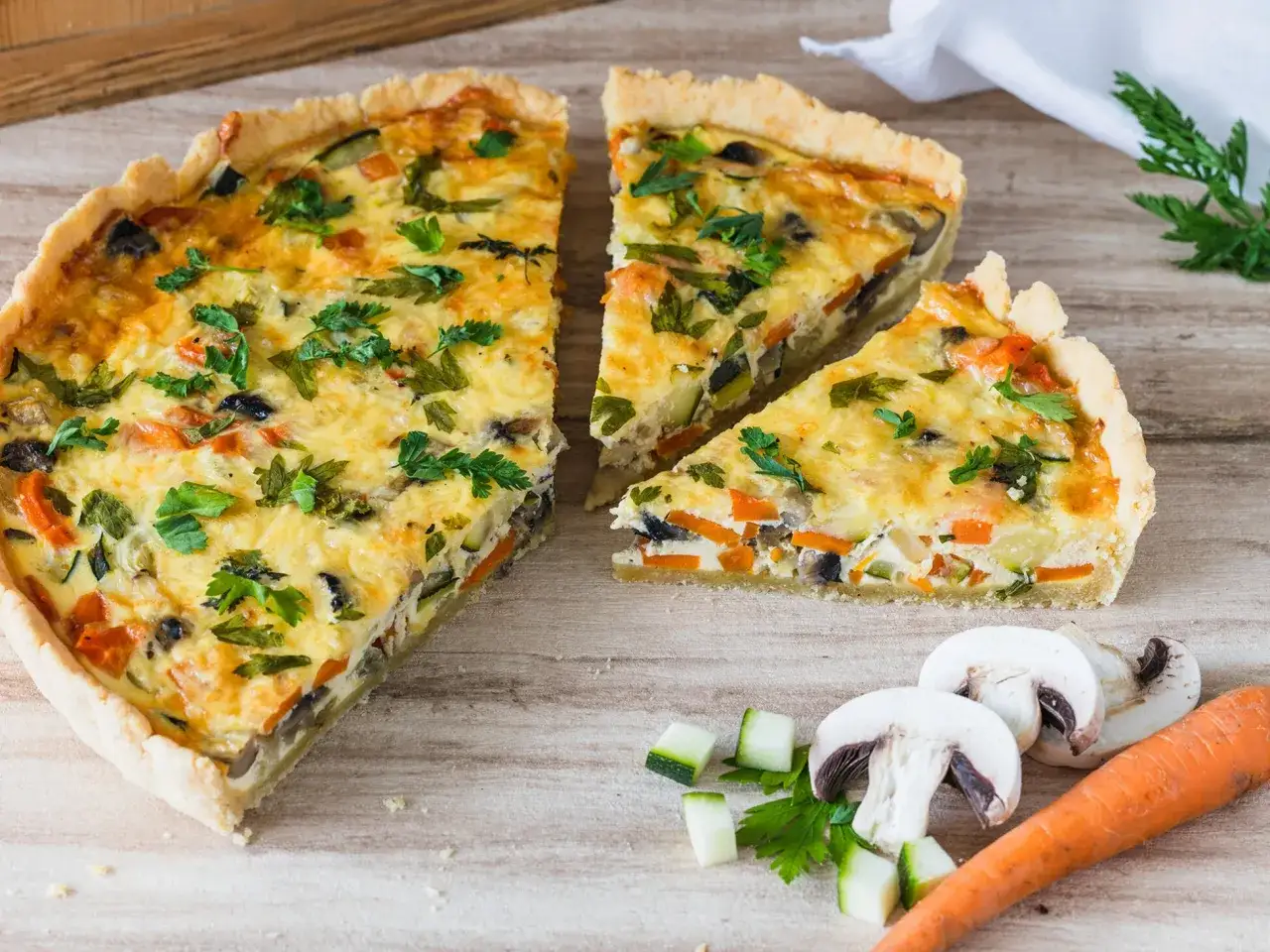 Herzhafte Quiche mit Gemüse, perfekt für Kinder. Bunte Karotten, Zucchini und Pilze in einer cremigen Füllung.
