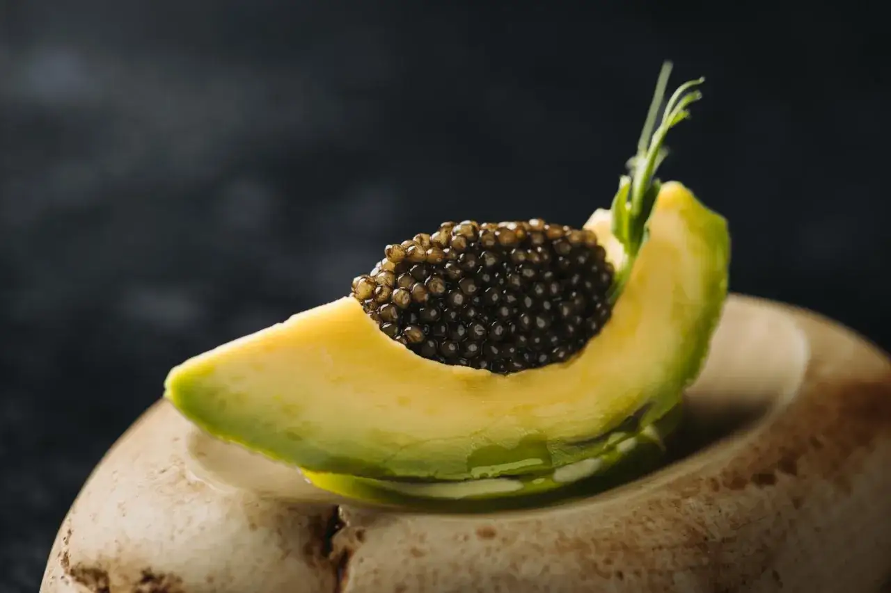 Rebanada de aguacate cremoso con caviar negro, una de las combinaciones más exquisitas entre los tipos de aguacate.