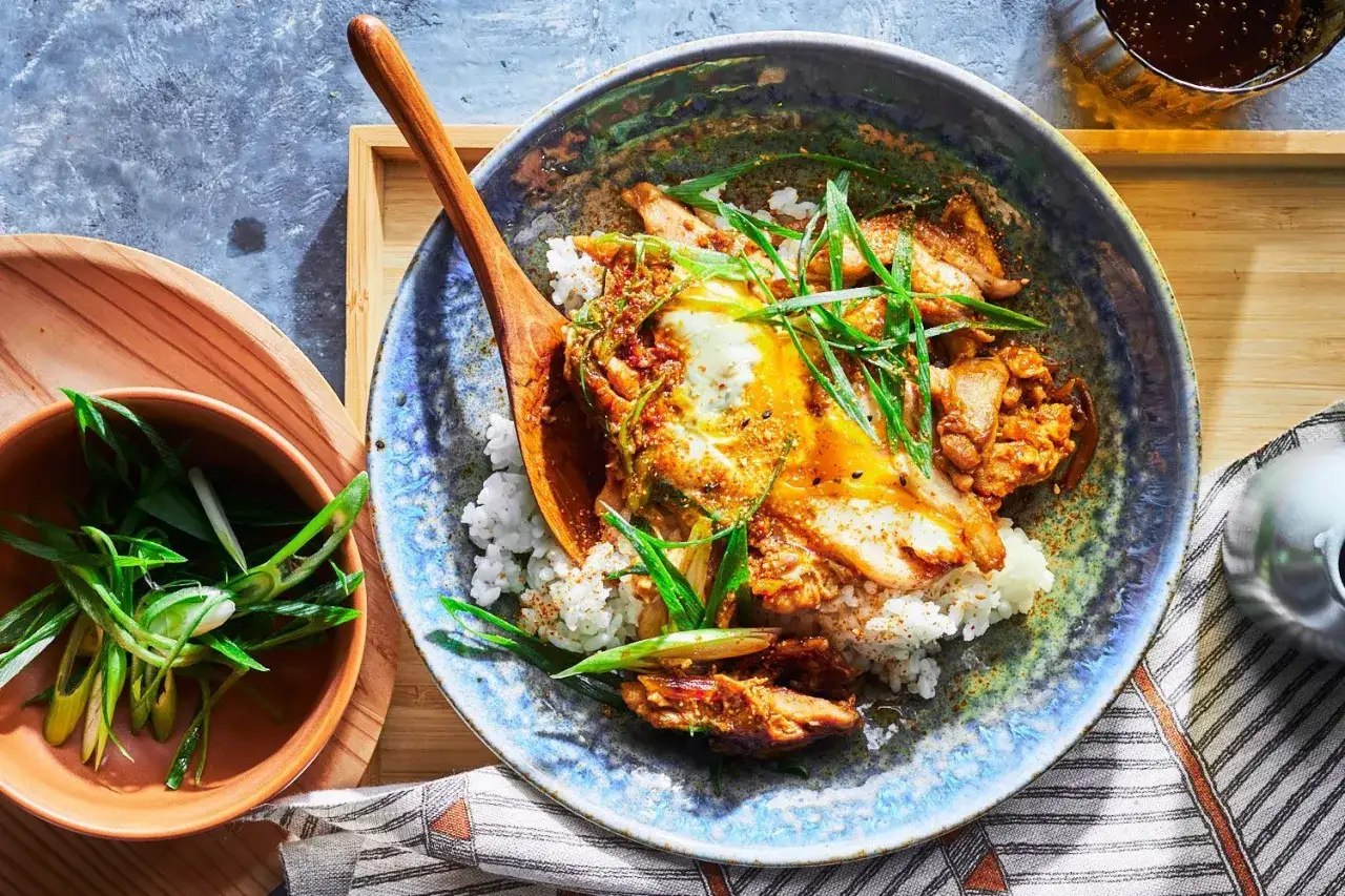 A delicious bowl of rice topped with glazed chicken and a fried egg, garnished with green onions. Perfect for easy Japanese recipes.