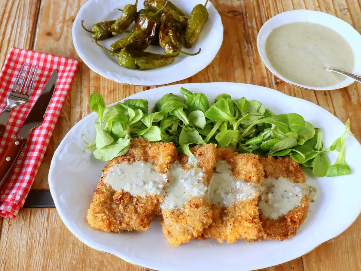 Escalopines al cabrales crujientes, servidos con ensalada verde y pimientos asados. &iexcl;Un plato delicioso!