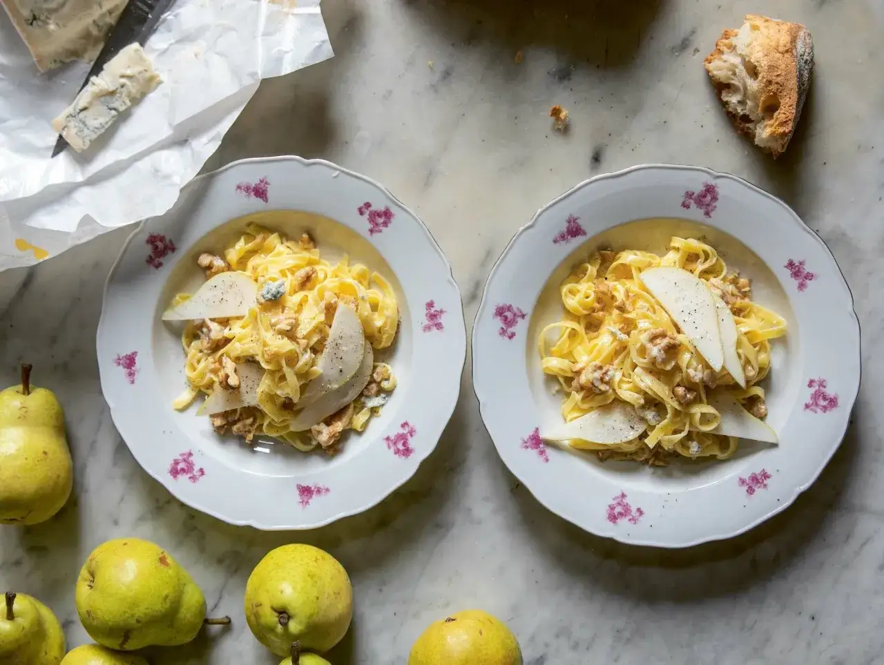 Deux assiettes de pâtes crémeuses aux noix et poires, garnies de gorgonzola. Un délice !