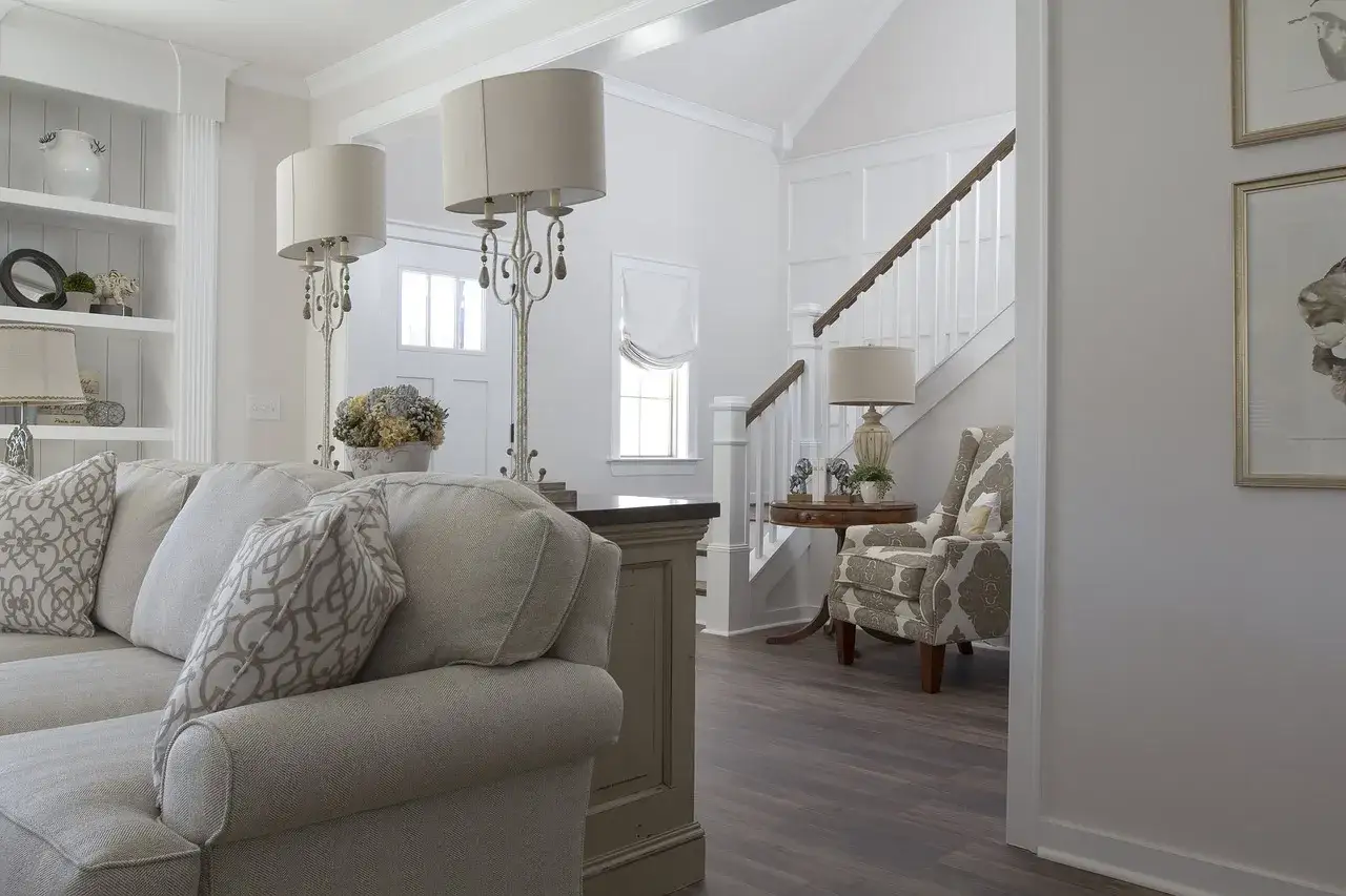 Sofá beige y dos lámparas de pie adornan este espacio. El mueble de la sala, con su diseño clásico, complementa los salones pequeños.