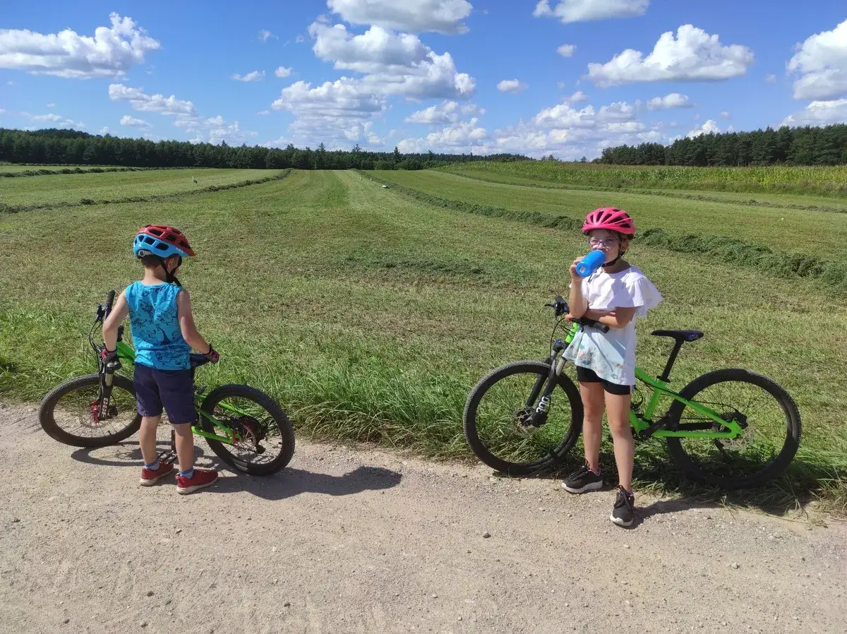 Dzieci na rowerach cieszą się piękną pogodą i odkrywają nowe trasy rowerowe dla dzieci.