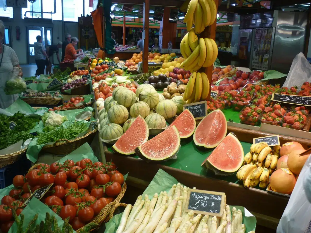 March&eacute; anim&eacute; avec des fruits et l&eacute;gumes de saison en mai : fraises, melons, tomates, asperges blanches, bananes.