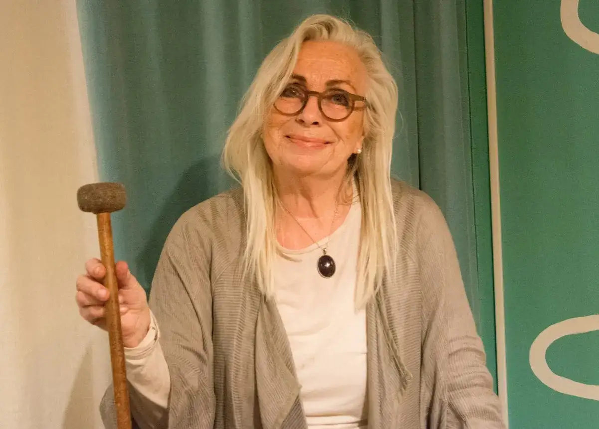 Marie Bergman, trots att hon kan k&auml;nna sig sjuk, ler och h&aring;ller en tr&auml;klubba.