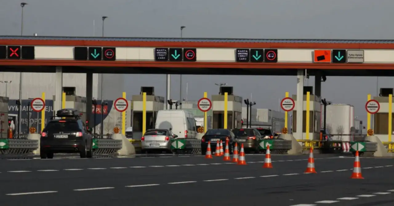 Kolejka samochodów na bramkach autostradowych. Czy autopay to rozwiązanie dla Ciebie? Zielone strzałki i znaki wskazują dostępne pasy.