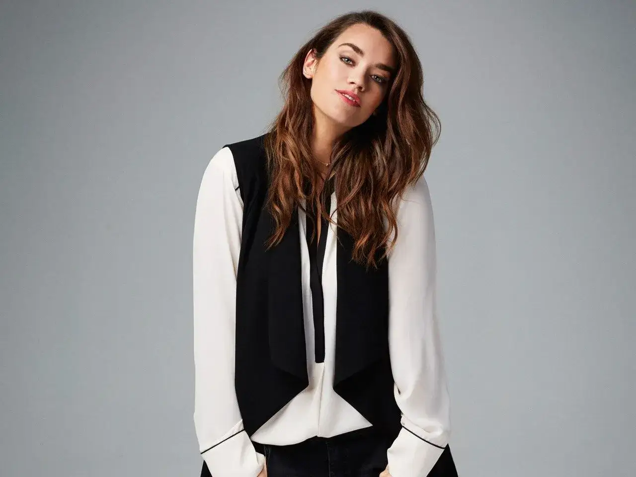 Elegancka kobieta w kamizelce i bluzce. Czy to Dorothy Perkins? Ta marka oferuje stylowe ubrania.