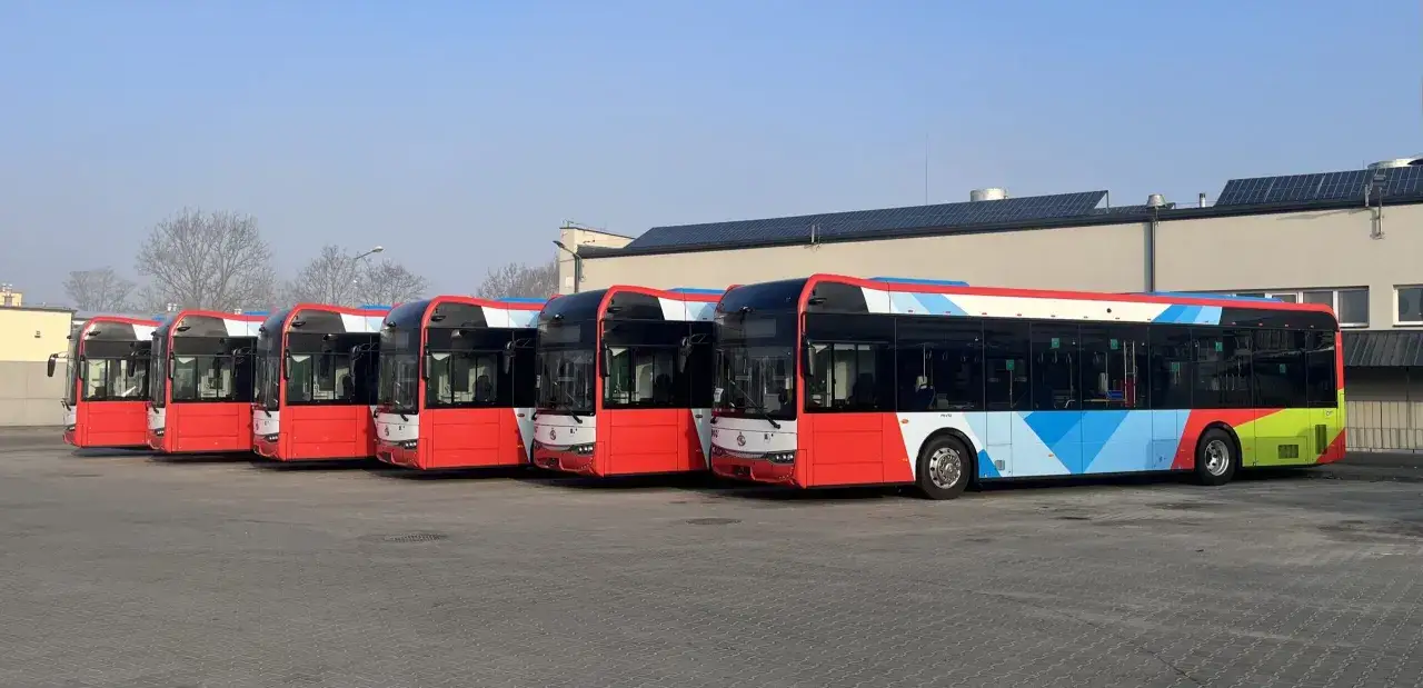 Rząd nowoczesnych autobusów 5 w jaskrawych kolorach, gotowych do wyjazdu.