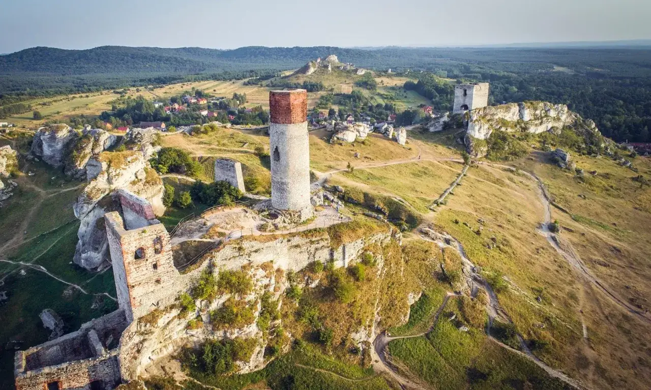Ruiny zamk&oacute;w na wapiennych skałach, w tym charakterystyczna wieża, tworzą malowniczy krajobraz Jury Krakowsko-Częstochowskiej.