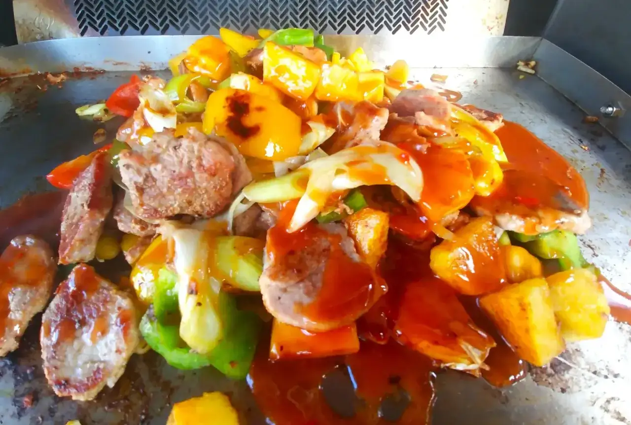 Délicieux porc à la plancha avec poivrons colorés et ananas, nappé d'une sauce savoureuse.