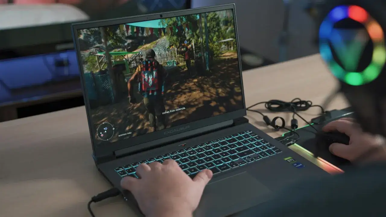 Gracz gra w grę na laptopie Excalibur z podświetlaną klawiaturą. Zastanawiasz się, ile kosztuje laptop do takich wrażeń?