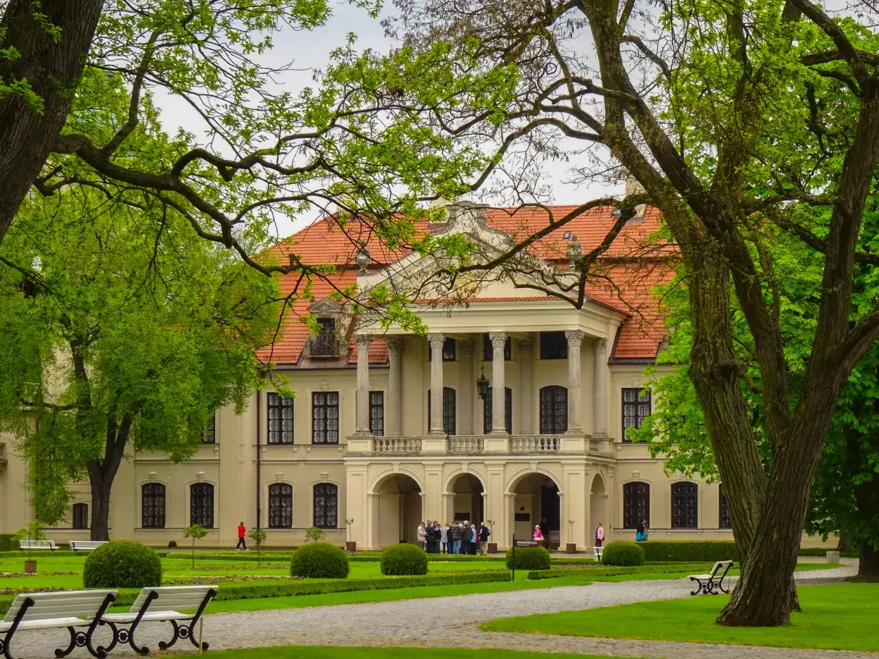 Pałac w Kozłówce, otoczony zielenią, zaprasza do zwiedzania. Wspaniałe **kozłówka atrakcje** czekają na odkrycie.