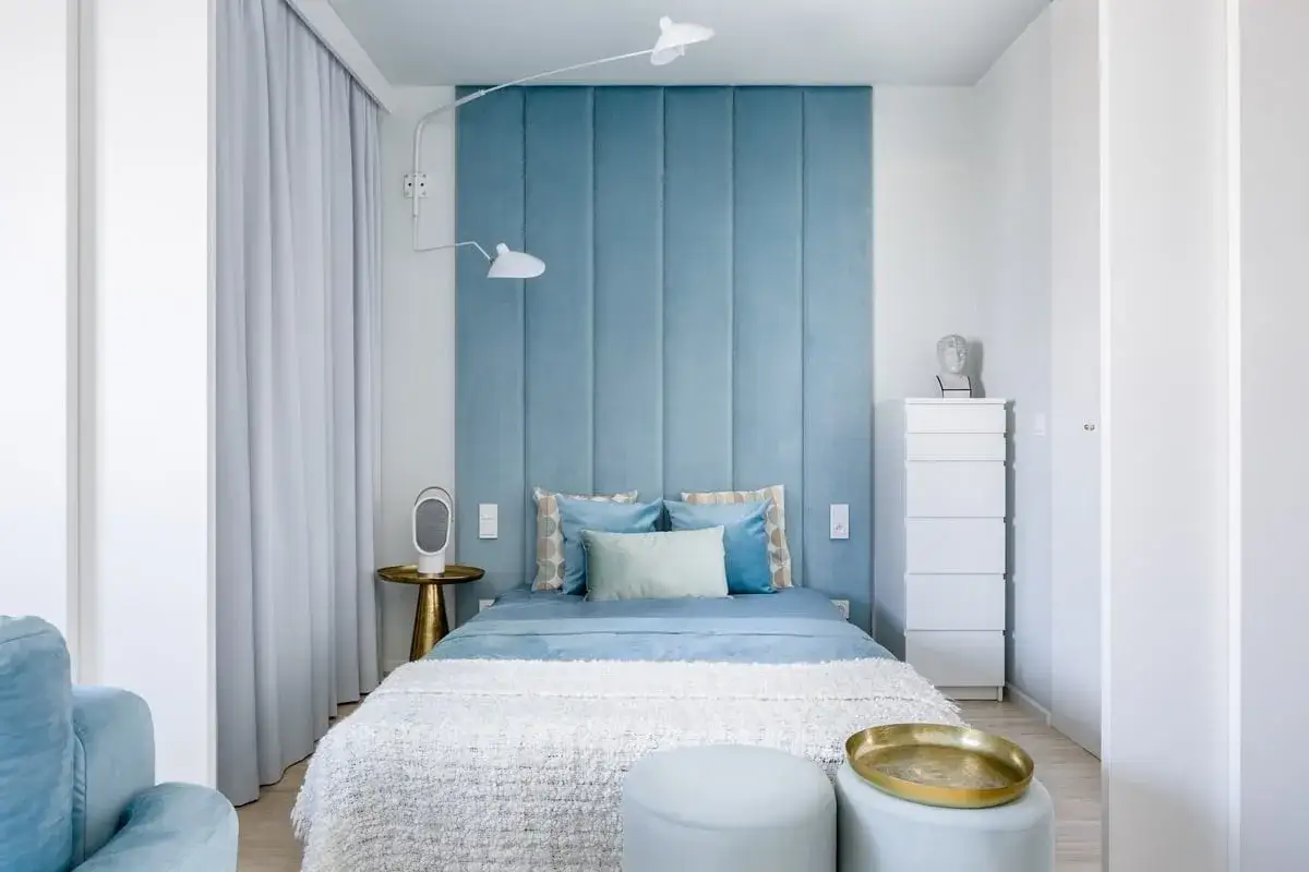 Schickes kleines Schlafzimmer streichen Ideen: Blaue Wandpaneele, ein Bett mit weißer Decke und ein goldener Beistelltisch schaffen Gemütlichkeit.