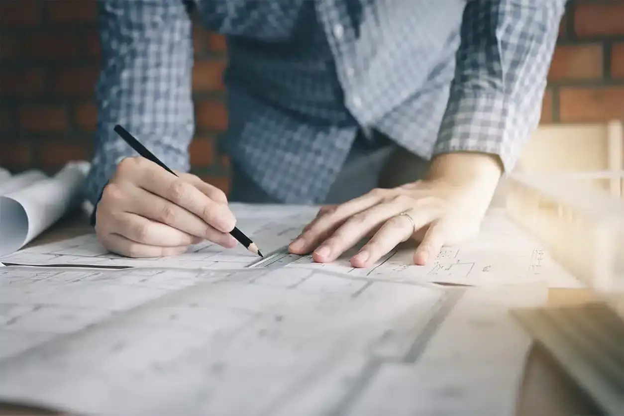 Manos de dise&ntilde;ador de interiores trabajando en planos. &iquest;Cu&aacute;nto te pagan por ser dise&ntilde;adora de interiores?