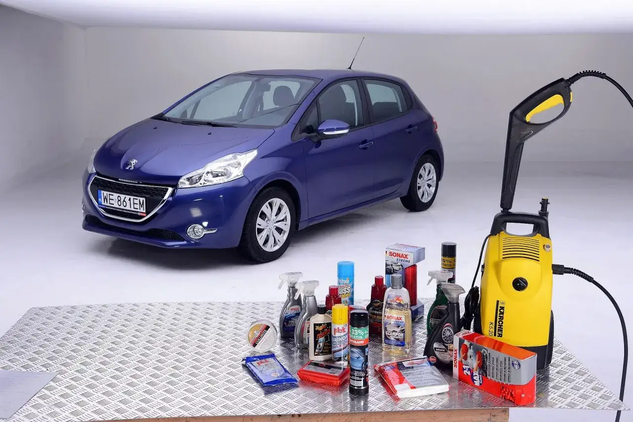 Niebieski Peugeot 208 obok myjki ciśnieniowej i zestawu kosmetyk&oacute;w samochodowych. Gdy nie ma szamponu, można użyć alternatywnych środk&oacute;w do umycia samochodu.