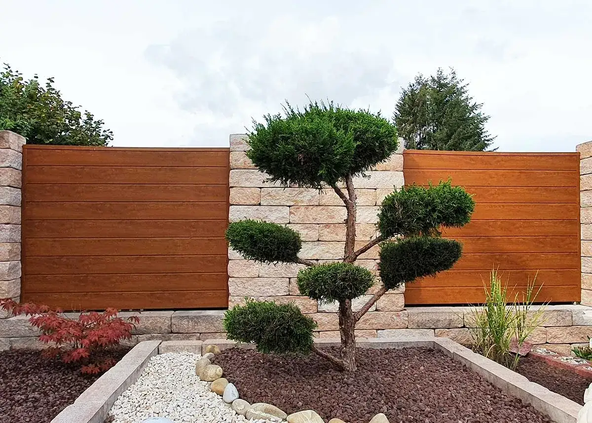 Moderne Gartenmauer mit Holzpaneelen und Steinpfeilern. Ein Bonsai-&auml;hnlicher Baum und ein japanischer Ahorn bieten tolle Ideen f&uuml;r die Gartengestaltung.