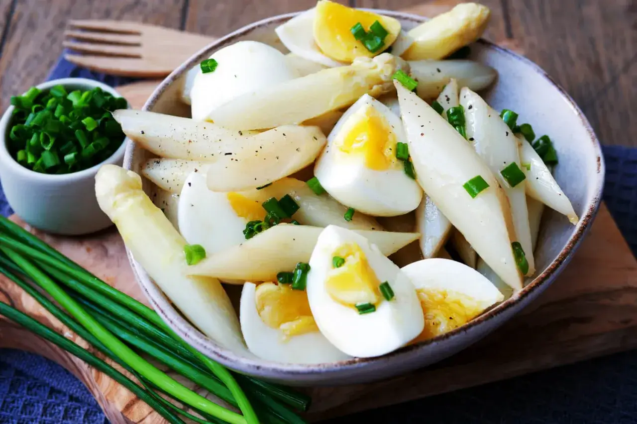 Klassisches Spargelsalat Rezept: Zarter weißer Spargel mit gekochten Eiern und Schnittlauch, garniert mit Pfeffer. Ein leichter Genuss.