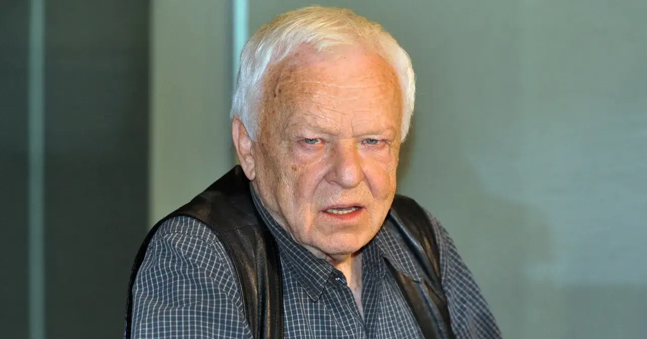 Marian Opani w czarnej kamizelce i koszuli w kratę. Wiele osób zastanawia się, ile lat ma Marian Opani.